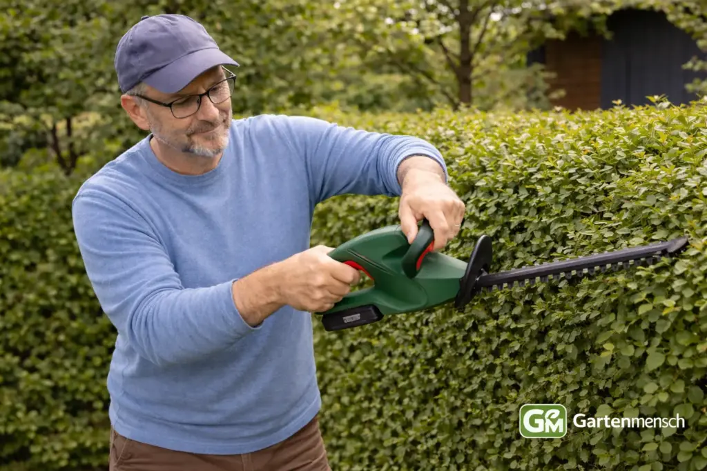 Tobias testet die Bosch EasyHedgeCut 18-45 Akku-Heckenschere beim Schneiden einer Hecke im Garten.